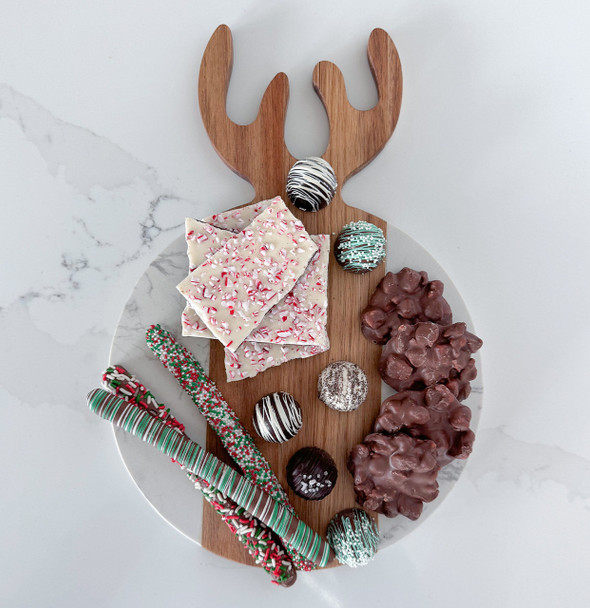 The Antler board is presented as a festive charcuterie display, artfully arranged with a variety of cured meats, cheeses, fruits, and crackers, perfect for holiday entertaining.