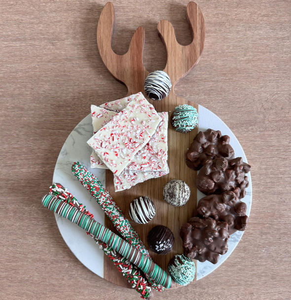 A beautiful holiday-themed food presentation on the Antler Acacia & Stone Round Board, featuring an assortment of appetizers that highlight the board's function as a unique and stylish serving piece.