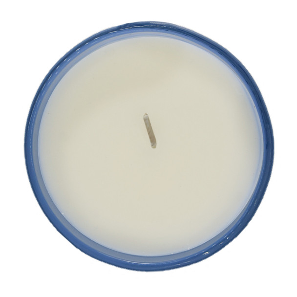 A top-down view of the unlit candle, showing the single wick centered in the smooth, white soy wax, all housed within the soft blue glass jar.