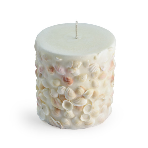 A clear product shot of the unlit seashell candle against a plain white background, highlighting the intricate texture and placement of the various real seashells embedded in the wax.