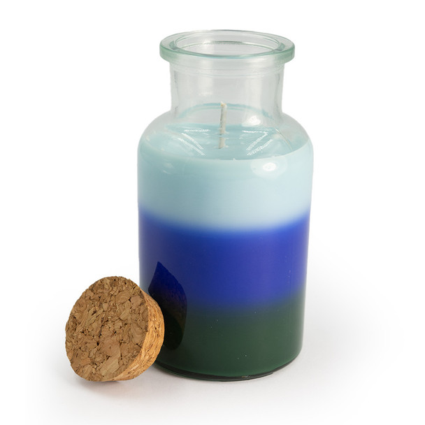 The apothecary jar candle is shown with its cork lid removed and placed beside it, providing a clear view of the top layer of wax and the single wick.