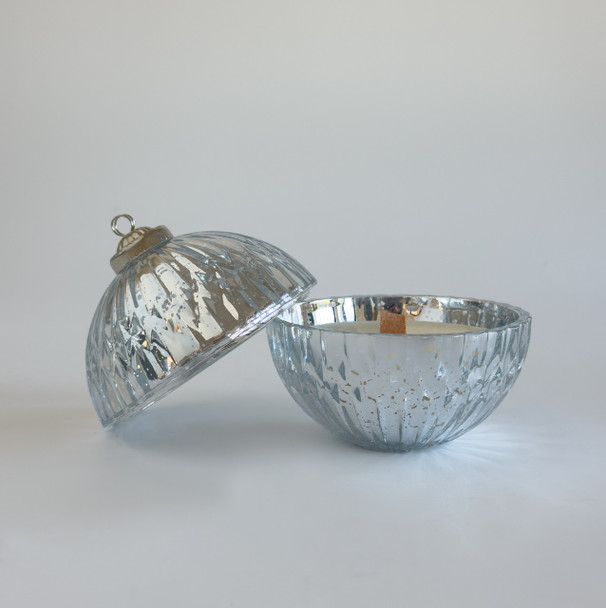 The two-piece mercury glass ornament candle is shown open against a white background, with the top half next to the bottom half which contains the unlit wood wick candle.