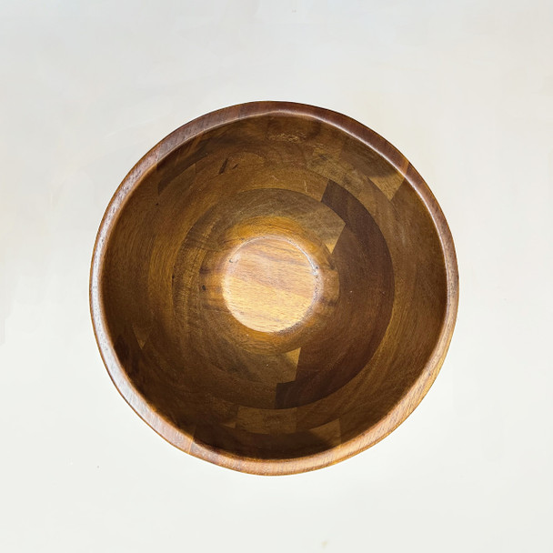 A close-up, top-down view of the interior of an acacia wood bowl, showcasing the natural wood grain, unique pattern, and texture.