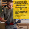 Contractor attaching a foam canister to a spray foam applicator gun in a workshop.