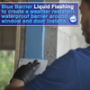 Contractor using a putty knife to apply blue liquid flashing to a window rough opening to create a waterproof barrier.