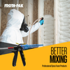 Contractor in a protective suit and respirator applying spray foam insulation to open wall studs for a seamless seal.