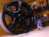 A car rm coated in matte black rubberized spray, sitting next to a can of Plasti Dip.