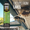 a can of Great Stuff Pro Pestblock foam sealant is shown near the eaves of a home with a wasp nest to demonstrate its use in preventing pests from nesting in those areas.