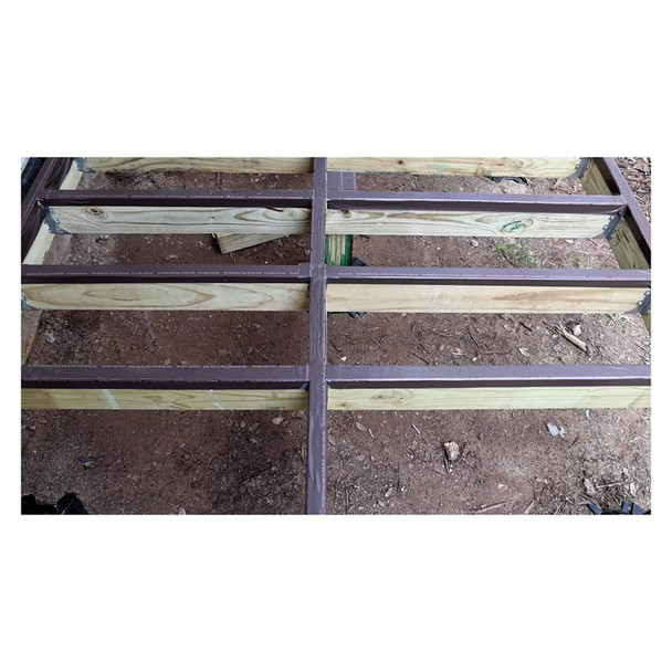 Top-down view of a wooden deck frame with brown joist tape applied to the top of the lumber to prevent moisture rot.