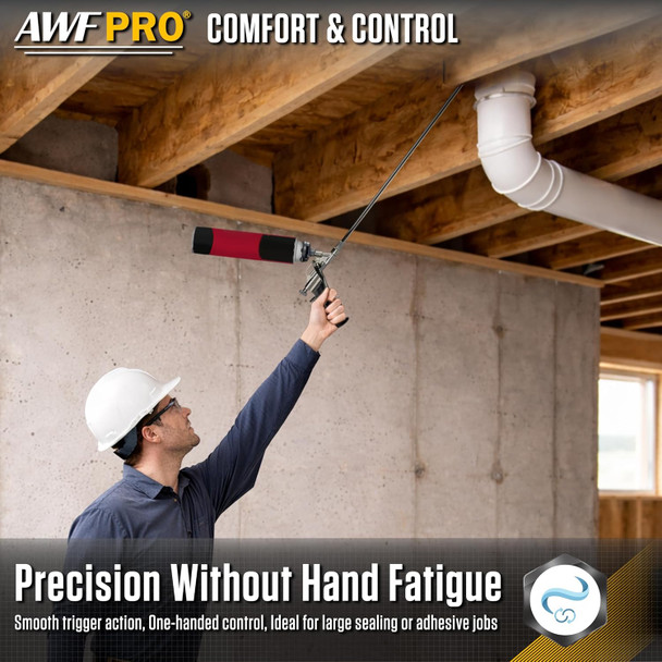 Contractor reaching overhead with an extended barrel spray foam gun to seal ceiling floor joists near plumbing.