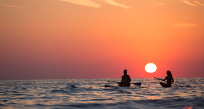 Couple enjoying sunset on their paddle board.