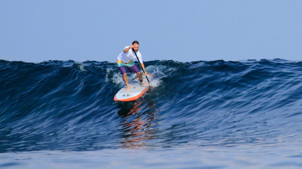 Man Sup surfing with a premium SUP paddle