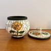 photo of the sunflower keepsake urn with the lid off. handmade ceramic keepsake urn with yellow hand painted sunflower.