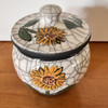 A picture of both the top and the base of this small handmade sunflower urn for ashes.