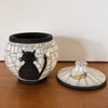 the black cat urn with the lid off.