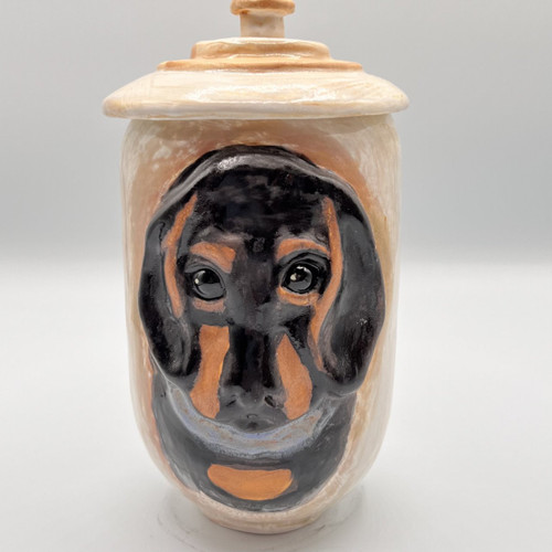 Ceramic Dachshund dog urn. The urn has a hand painted face of a black and tan dachshund dog. handmade