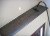 A 130 Degree Curved Extension Wand cleaning a ledge above a doorway.