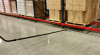 A long wand cleaning under a shelf in a warehouse.