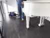 Person using Sidewinder connected to the C105 vacuum to clean under a piano.