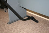 Cleaning the carpet underneath an office table.