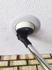 Dust brush attached to chrome wand cleaning inset light on ceiling.