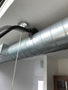 Close up of Reach ventilation tool being used to clean a ventilation duct with a translucent image over it showing the motion of the tool.