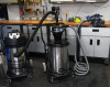 An industrial vacuum connected to a separator which is in turn connected to a circular saw in a garage.