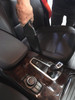 Crevice tool cleaning between console and seat in car.