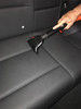 Upholstery tool cleaning the seat in a car.
