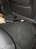 Crevice tool cleaning underneath the back of a car seat.