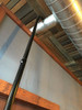 Reach pipe cleaning tool cleaning a small ventilation duct.