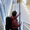 Person wearing backpack vacuum using Reach to clean with phone and camera connected.