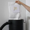 Someone pulling a vacuum bag out of the top of Aeon vacuum.