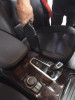 Crevice tool cleaning between console and seat in car.
