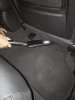 Crevice tool cleaning underneath the back of a car seat.