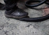 Close up of someone stepping on a black hose.