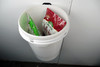 Bags of seeds in wall mounted bucket.
