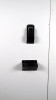 Black plastic wall mount pieces mounted onto white wall.