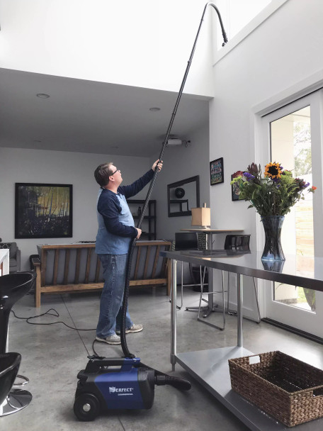 Person using Reach poles connected to the C105 vacuum to clean high ceiling area. Person using Reach poles connected to the C105 vacuum to clean high ceiling area.