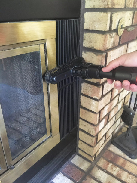 Person cleaning a fireplace with 8 inch wide Sidewinder brush.