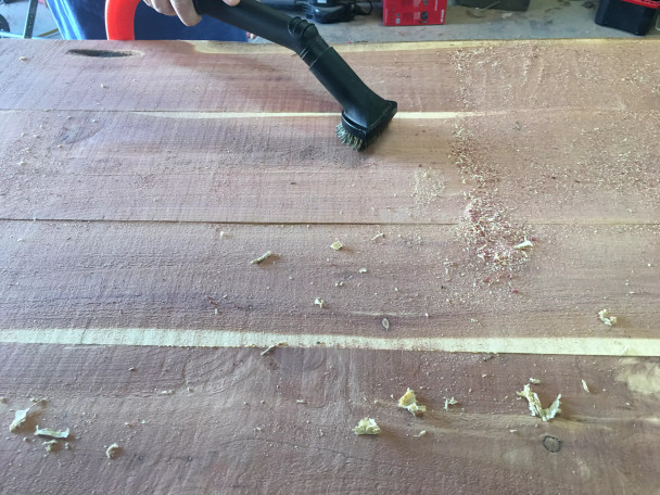 Dust brush tool cleaning sawdust off of workspace.