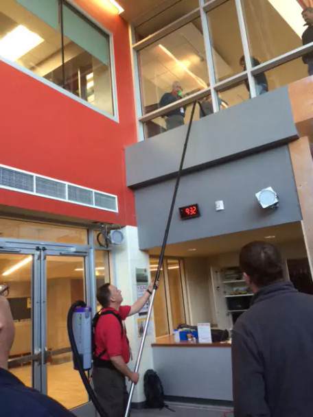 Person using Reach to clean a second story ledge.