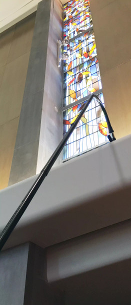 Reach with Sidewinder brush cleaning ledge in a church.