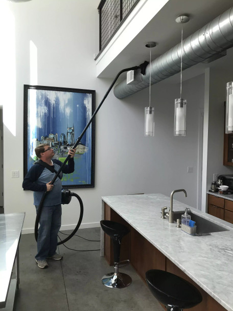 Person using Reach to clean ventilation duct in kitchen.
