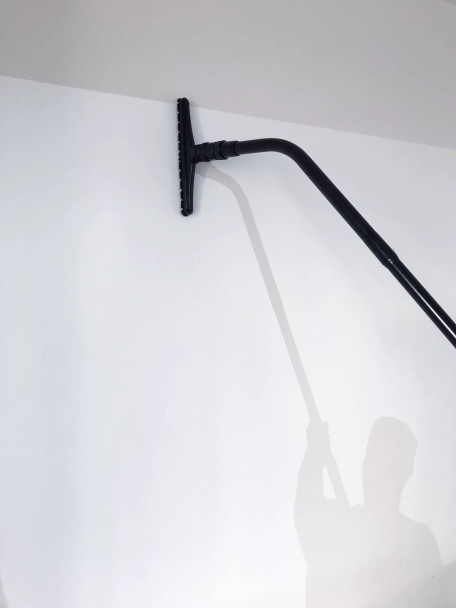 Person using Reach with Sidewinder brush to clean wall.