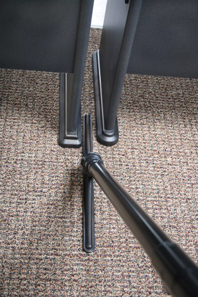 Sidewinder cleaning small space between two desks.