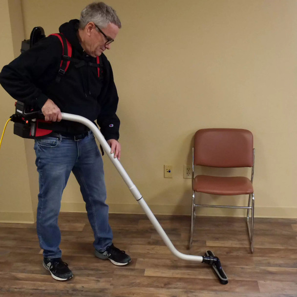 Person with Perfect Power 6 quart backpack vacuum cleaning hardwood floor.