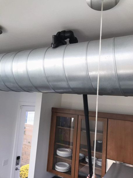 Ventilation tool cleaning ventilation duct in a kitchen.