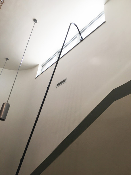 Reach with Sidewinder brush cleaning window ledge in stairway.