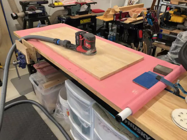 Quick Click hose and adapter attached to a hand sander tool.